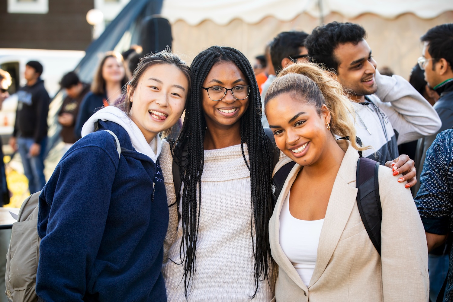 Students standing outside smiling at an event.