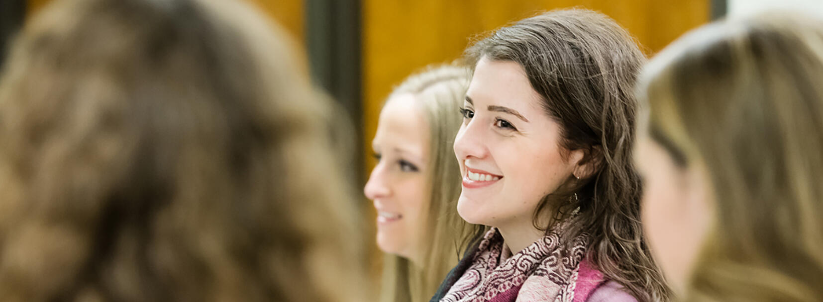 Female student sitting with students smiling