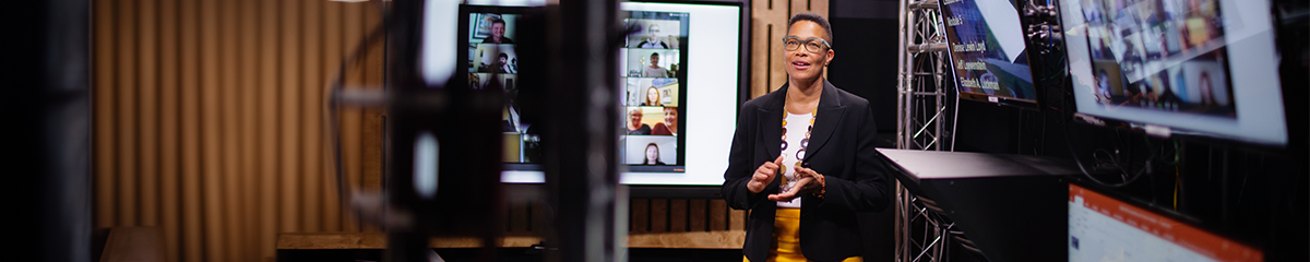 Gies faculty member teaching students online in a studio